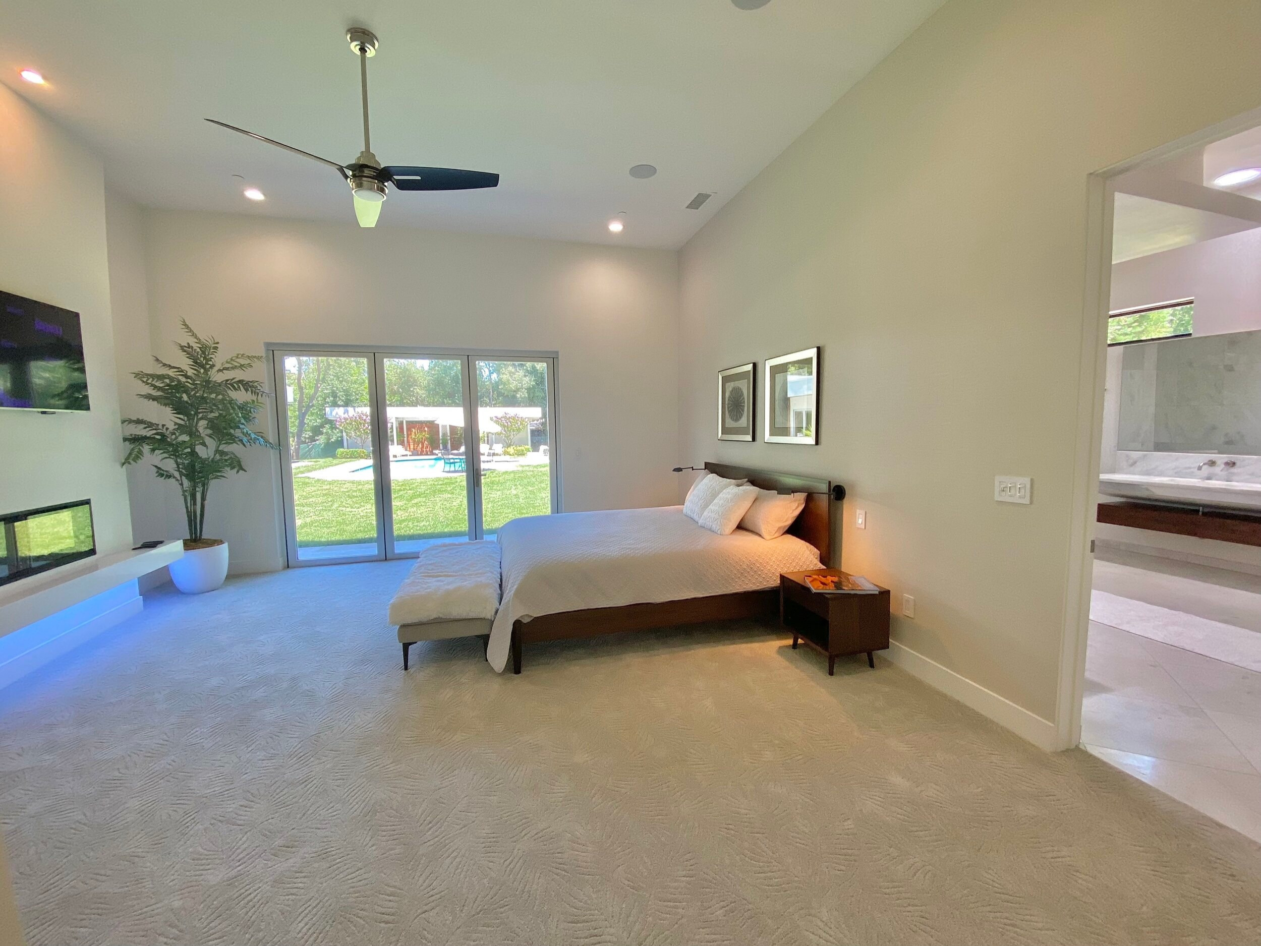 Spacious bedroom with a fireplace and glazed doors facing the garden