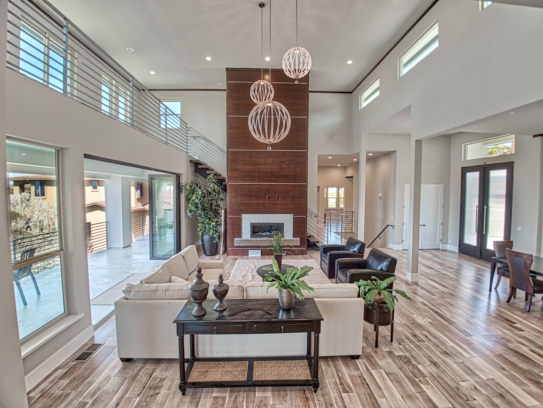 Two-story great room with a floor-to-ceiling wood fireplace wall